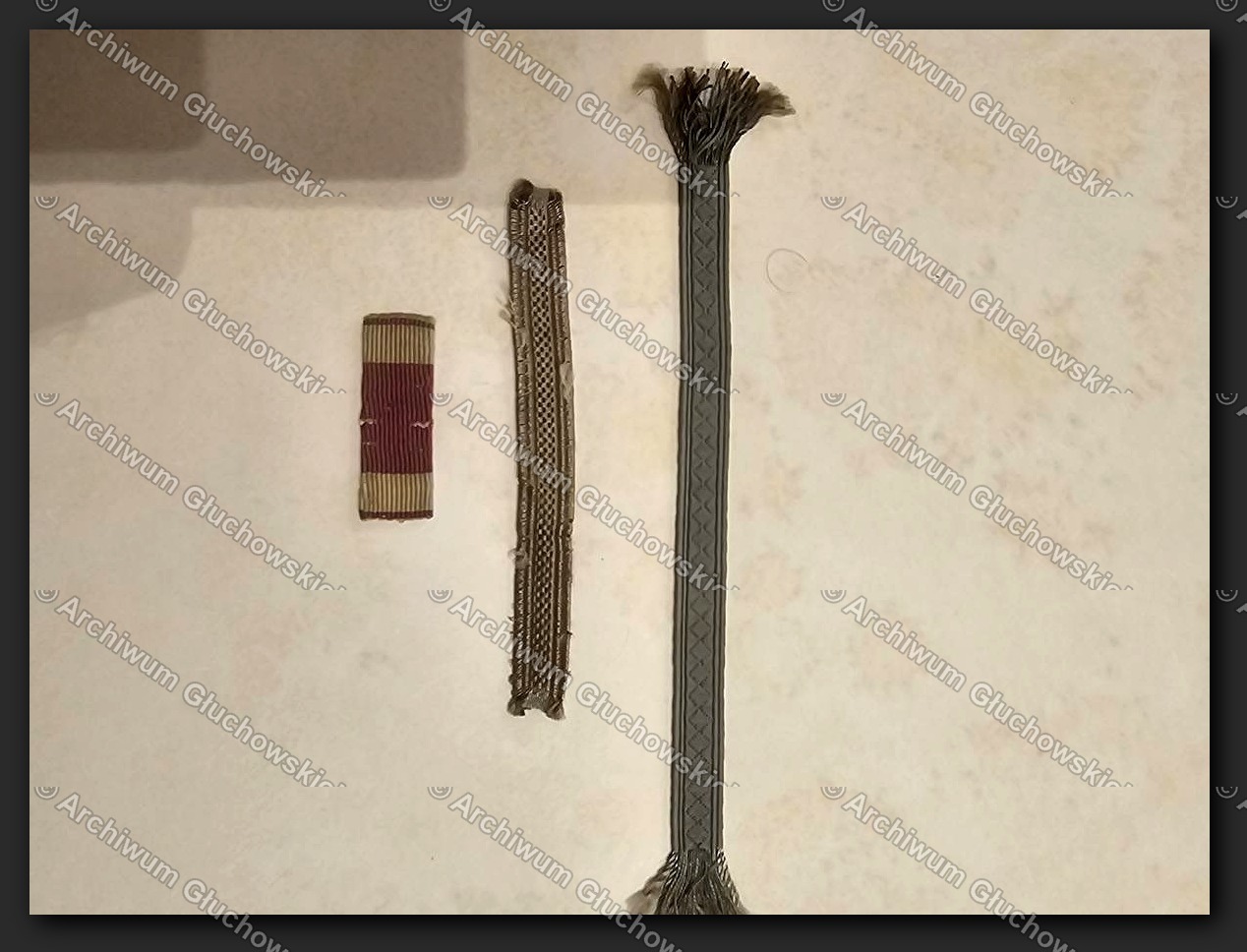 Trzy elementy mundurowe oficerskie — baretka orderowa, galon i temblak (węzeł szablowy)