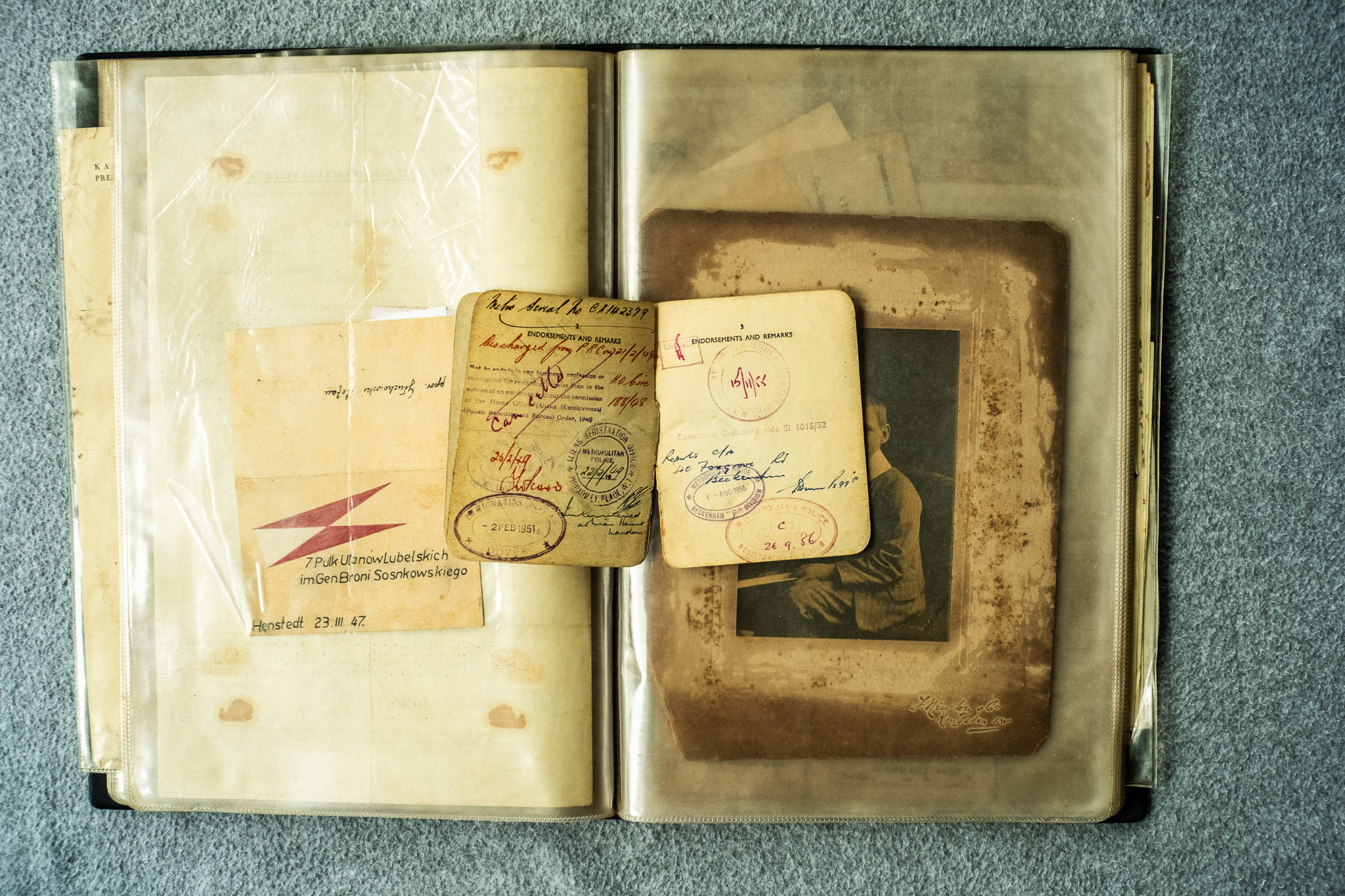 Fotografia portretowa formatu cabinet młodego mężczyzny (sepia, atelier) zachowana w teczce dokumentów emigracyjnych Janusza — atrybucja: prawdopodobnie Janusz Głuchowski w młodości (~1908-1920)